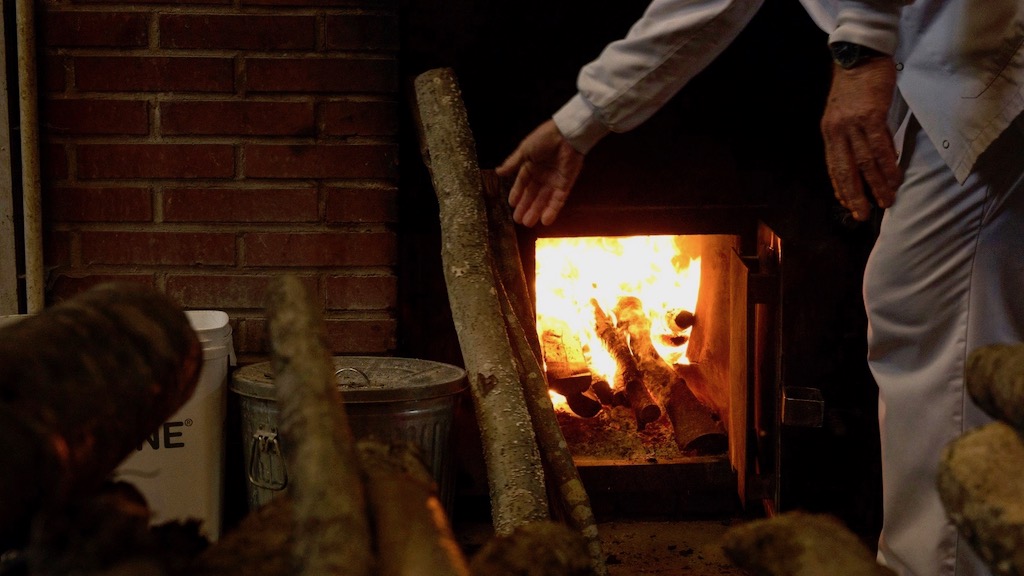 Putting wood into a fire